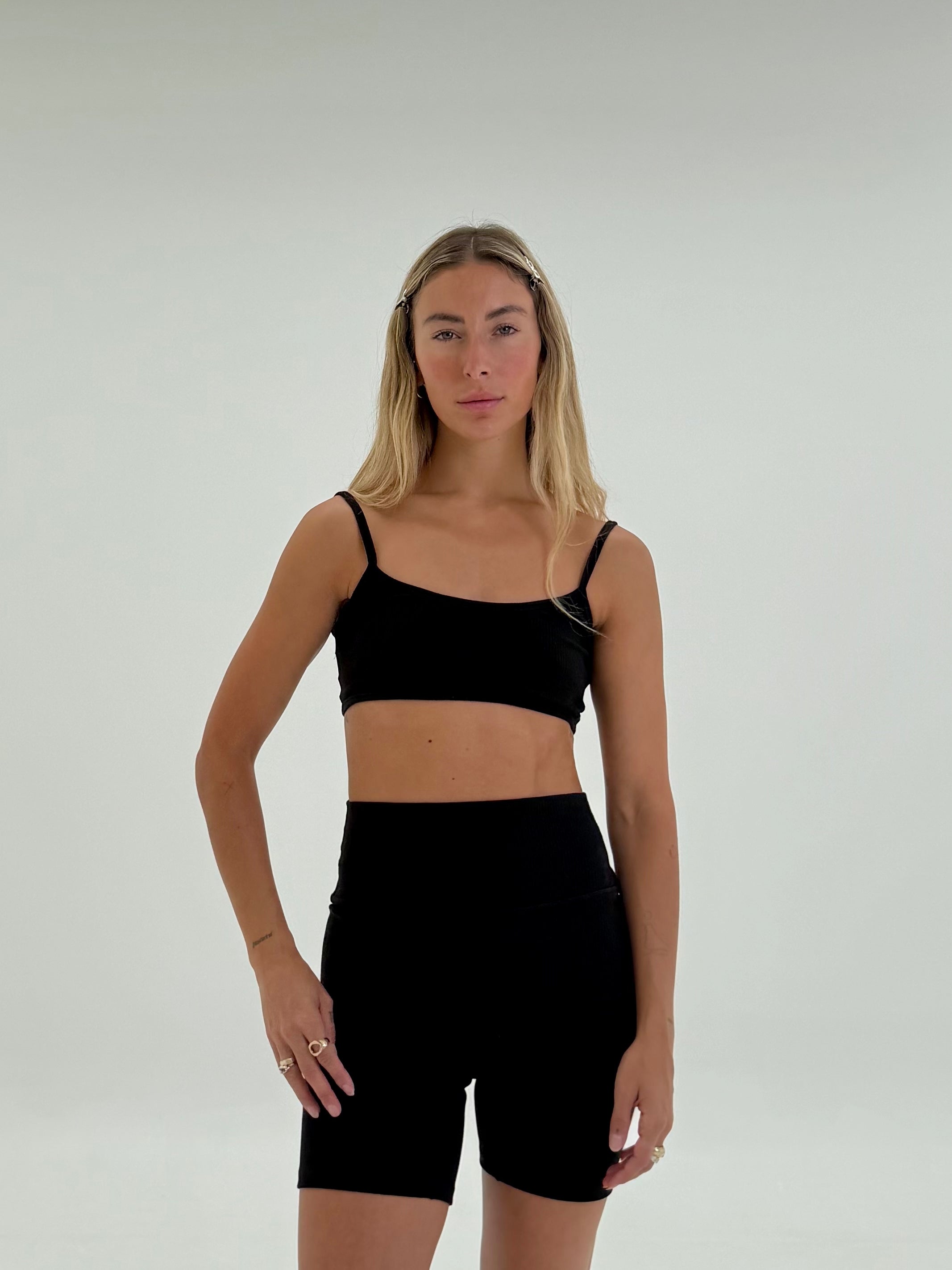 front view of girl wearing organic ribbed black yoga set